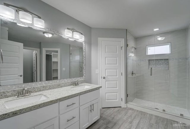 3708 Climax Dr, Edinburg, TX 78542 - bathroom with wood finished floors, a shower stall, double vanity, and a closet