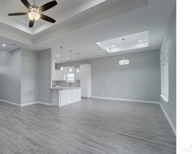 3708 Climax Dr, Edinburg, TX 78542 - unfurnished living room with a tray ceiling, wood finished floors, recessed lighting, and ceiling fan