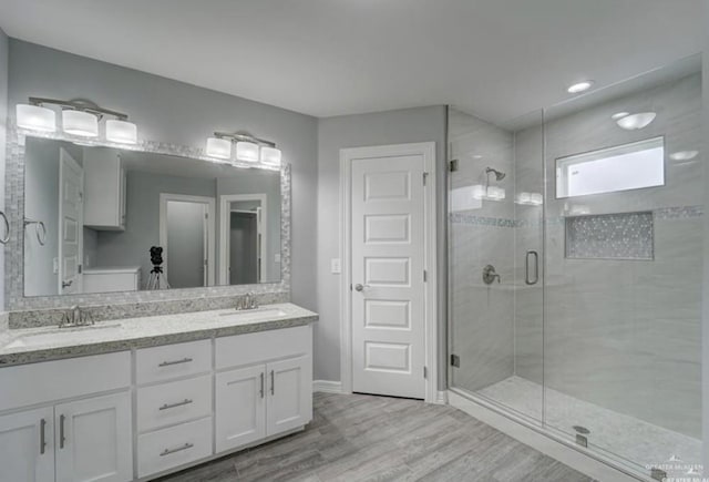 3708 Climax Dr, Edinburg, TX 78542 - bathroom with wood finished floors, a shower stall, and double vanity