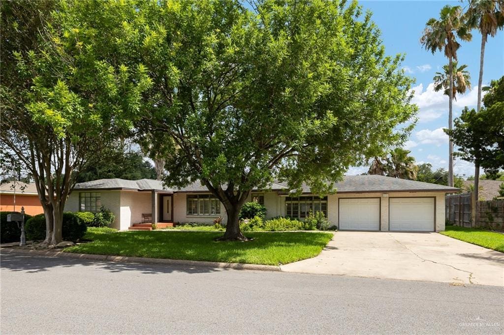 1117 Highland Ave, Mcallen, TX 78501 - view of front of home with an attached garage, concrete driveway, and stucco siding