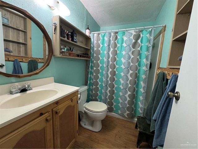 bathroom with hardwood / wood-style floors, vanity, toilet, a textured ceiling, and walk in shower