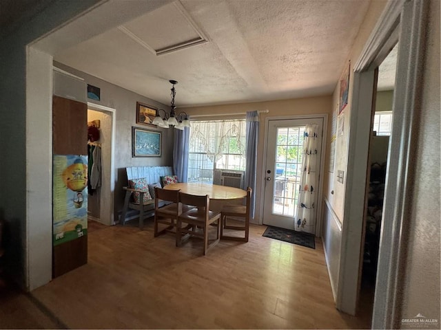 dining space with a chandelier, a textured ceiling, and hardwood / wood-style flooring