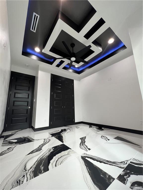 1505 W Kennedy Ave, Alton, TX 78573 - unfurnished bedroom with a raised ceiling and baseboards