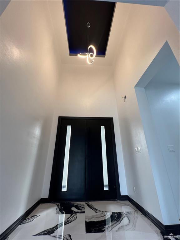 1505 W Kennedy Ave, Alton, TX 78573 - entryway featuring baseboards, marble tiled flooring, and a chandelier