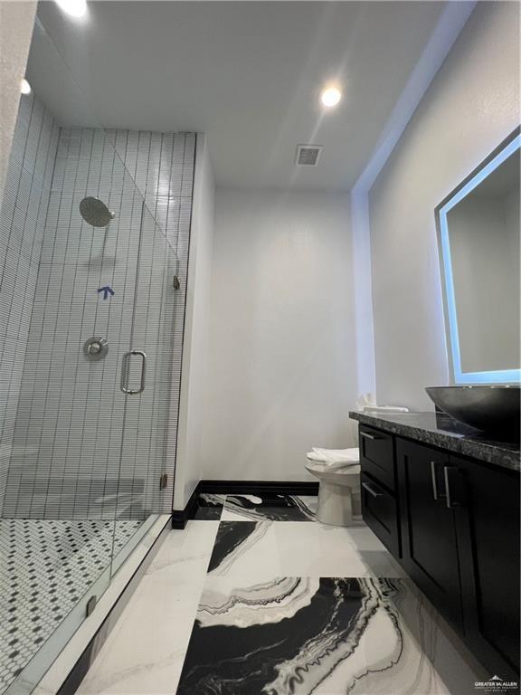1505 W Kennedy Ave, Alton, TX 78573 - bathroom with marble look tiles, a stall shower, vanity, toilet, and recessed lighting