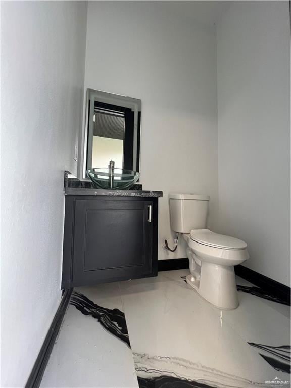 1505 W Kennedy Ave, Alton, TX 78573 - bathroom featuring toilet, vanity, and baseboards