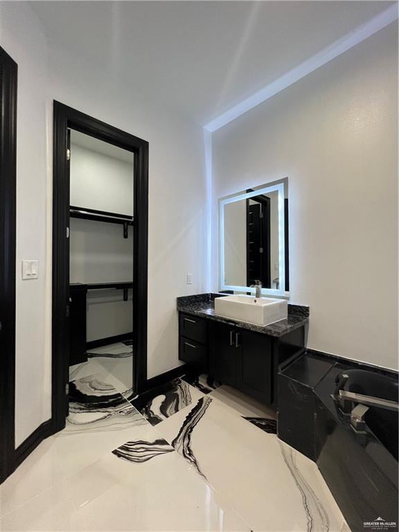 1505 W Kennedy Ave, Alton, TX 78573 - bathroom with vanity, baseboards, and a spacious closet