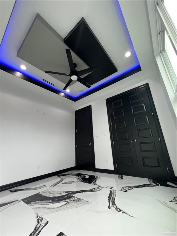 1505 W Kennedy Ave, Alton, TX 78573 - interior space with a tray ceiling, baseboards, recessed lighting, marble tiled flooring, and a ceiling fan