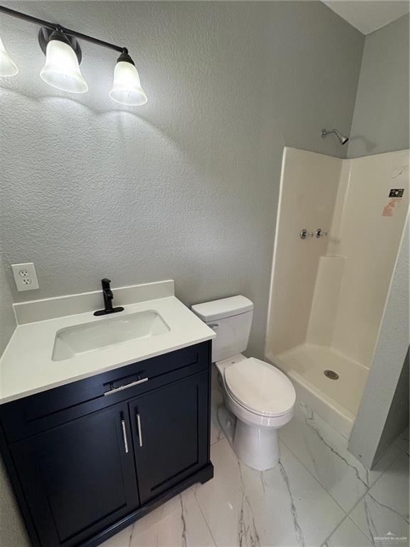 bathroom with vanity, toilet, and a shower