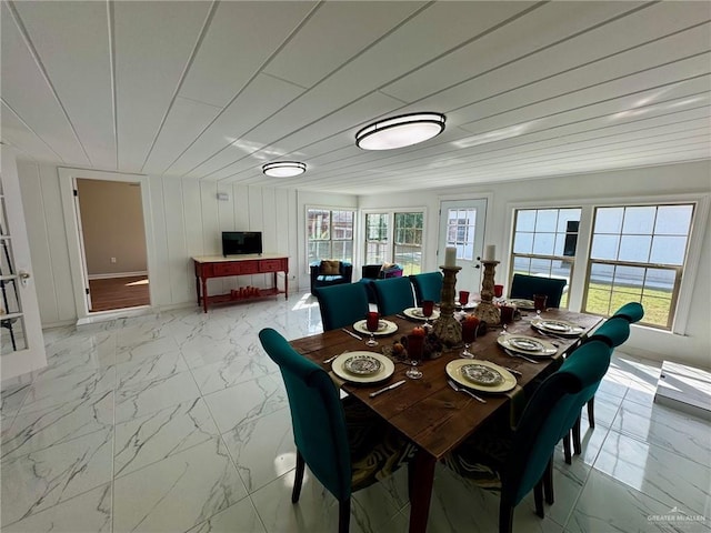 dining space featuring wooden ceiling, wooden walls, and a healthy amount of sunlight