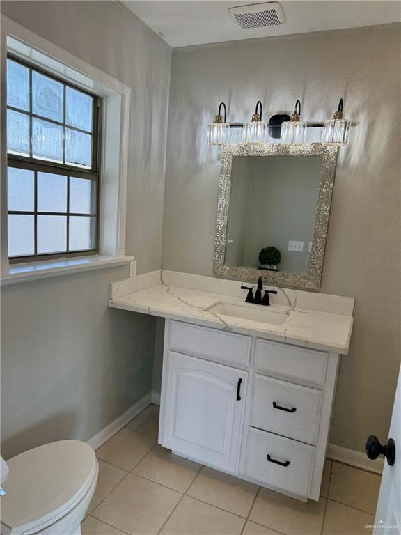 bathroom featuring tile patterned flooring, vanity, and toilet