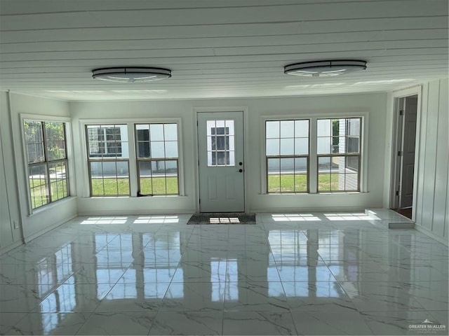 unfurnished sunroom featuring wood ceiling and a wealth of natural light