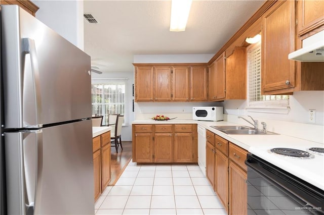 200 E Yuma Ave Unit 5, Mcallen, TX 78503 - kitchen featuring white appliances, light countertops, brown cabinetry, and under cabinet range hood