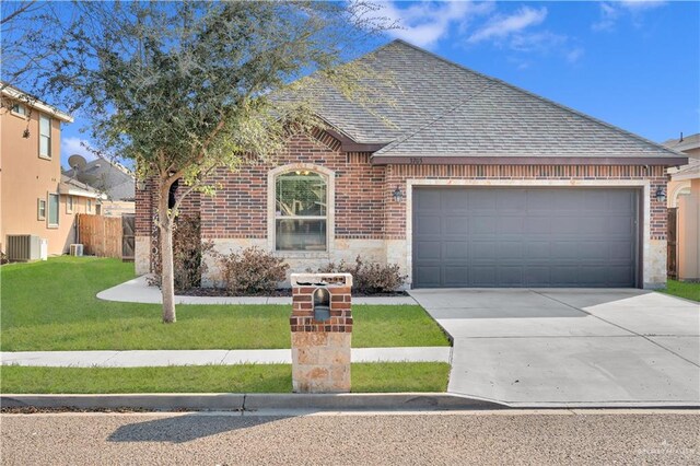 view of front of property with a garage, cooling unit, and a front lawn