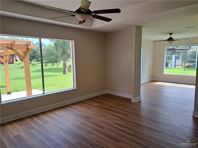 unfurnished room featuring dark wood-type flooring and ceiling fan