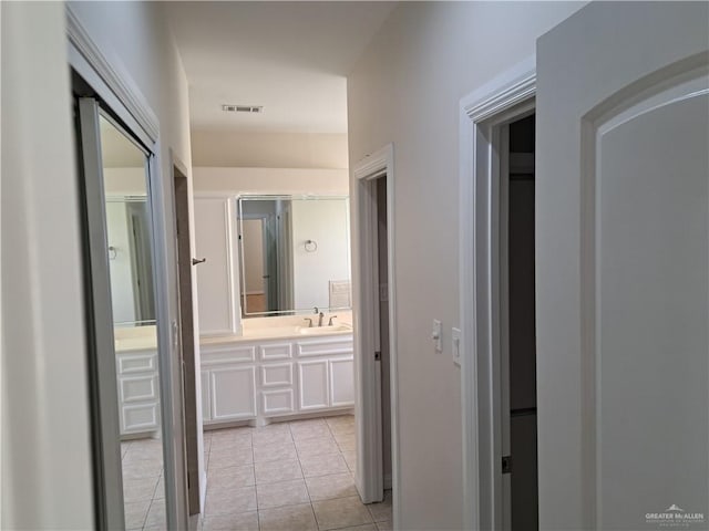 corridor with sink and light tile patterned floors