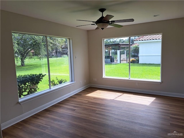 unfurnished room with ceiling fan, a healthy amount of sunlight, and wood-type flooring