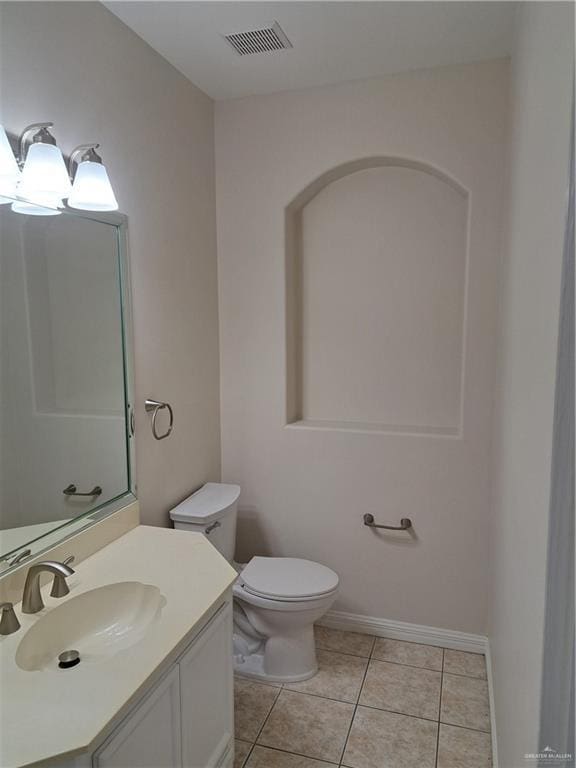 bathroom featuring vanity, tile patterned floors, and toilet