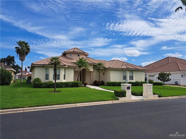 mediterranean / spanish-style home featuring a front yard