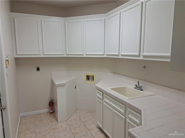 washroom with sink, cabinets, washer hookup, light tile patterned floors, and electric dryer hookup