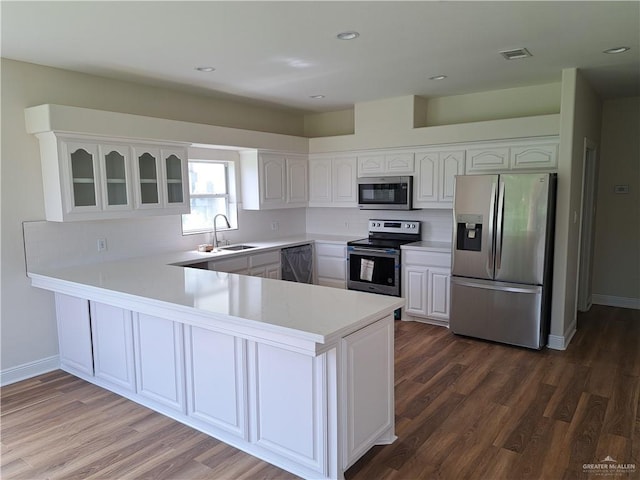 kitchen with stainless steel appliances, white cabinetry, and kitchen peninsula