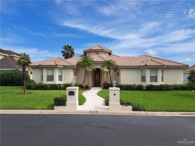 mediterranean / spanish-style house with a front yard