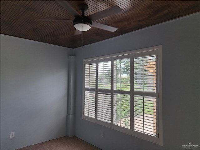 empty room with ceiling fan, light tile patterned floors, and wood ceiling