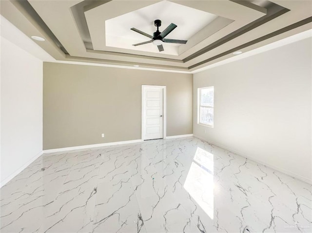 empty room featuring ceiling fan, crown molding, and a tray ceiling