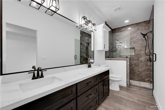 bathroom featuring vanity, an enclosed shower, and toilet