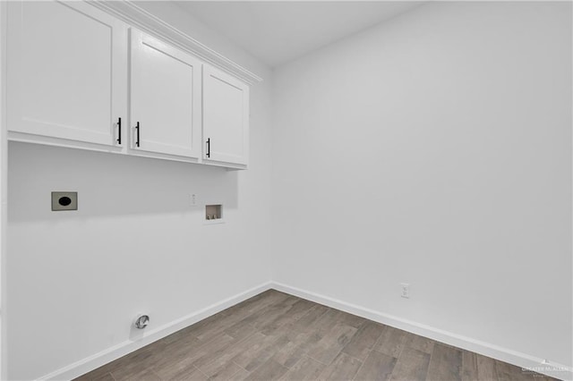 washroom with electric dryer hookup, cabinets, hookup for a washing machine, and wood-type flooring