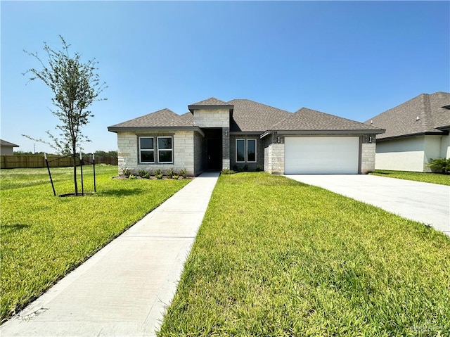 view of front of property featuring a garage and a front lawn