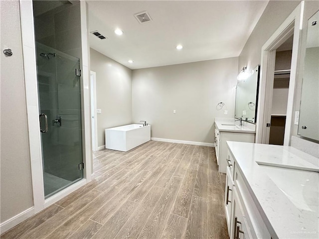 bathroom featuring separate shower and tub, hardwood / wood-style floors, and vanity