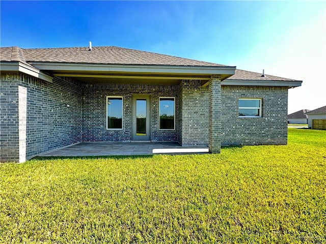 rear view of house with a yard and a patio