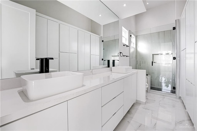 bathroom with toilet, an enclosed shower, and vanity