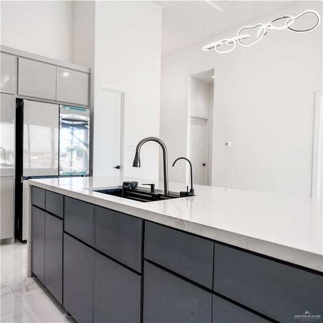 4713 S Brazos Rd S, Edinburg, TX 78542 - kitchen featuring gray cabinetry, fridge, light stone countertops, light marble finish floors, and modern cabinets