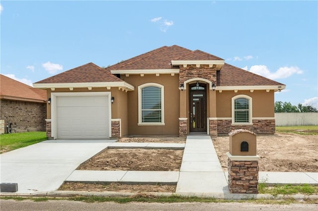 mediterranean / spanish house with a garage, stone siding, driveway, and stucco siding