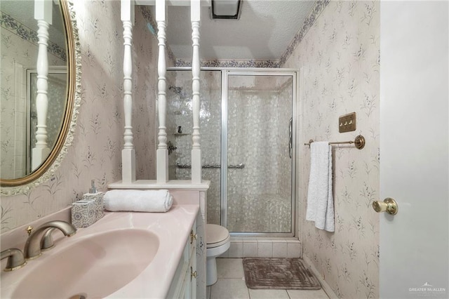 bathroom with tile patterned floors, toilet, a shower with shower door, and vanity