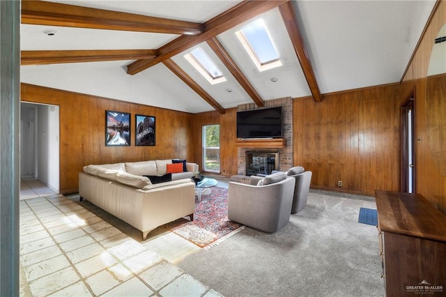 carpeted living room with lofted ceiling with skylight, a brick fireplace, and wood walls