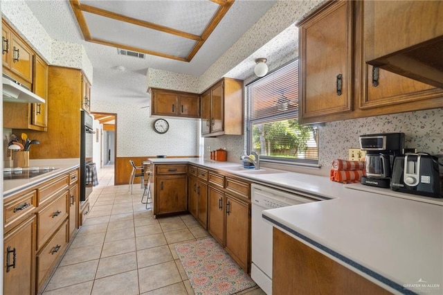 kitchen with dishwasher, sink, double wall oven, light tile patterned floors, and black electric cooktop