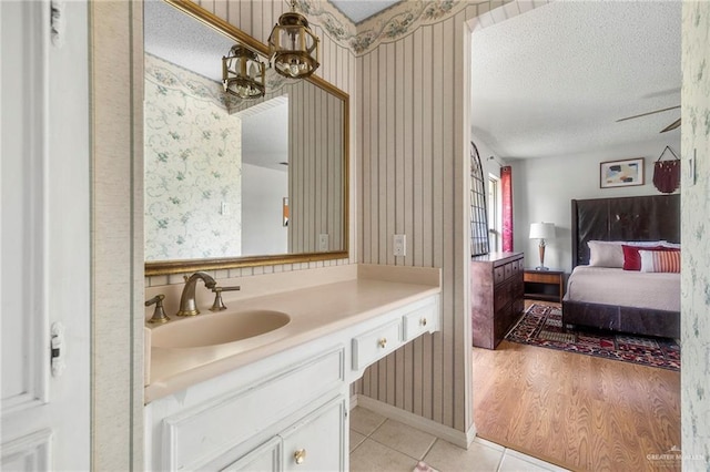 bathroom featuring tile patterned flooring, vanity, a notable chandelier, and a textured ceiling