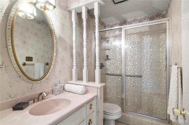 bathroom featuring vanity, an enclosed shower, and toilet