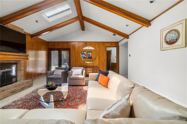 living room featuring vaulted ceiling with beams, wooden walls, carpet floors, a fireplace, and french doors