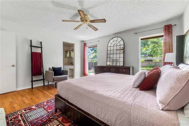 bedroom featuring hardwood / wood-style flooring, ceiling fan, and a textured ceiling