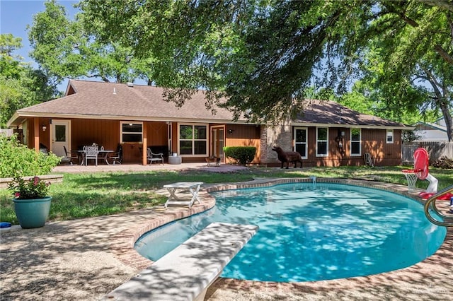 view of swimming pool featuring a diving board and a patio area