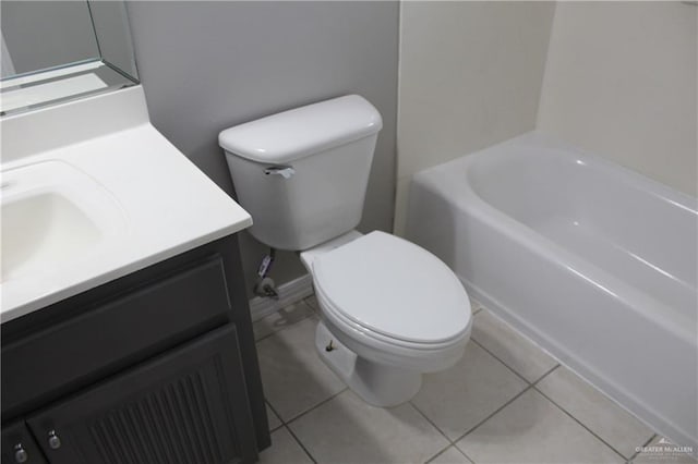 bathroom featuring toilet, tile patterned floors, vanity, and a bathtub