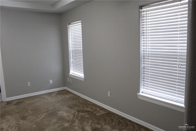 empty room featuring carpet and baseboards