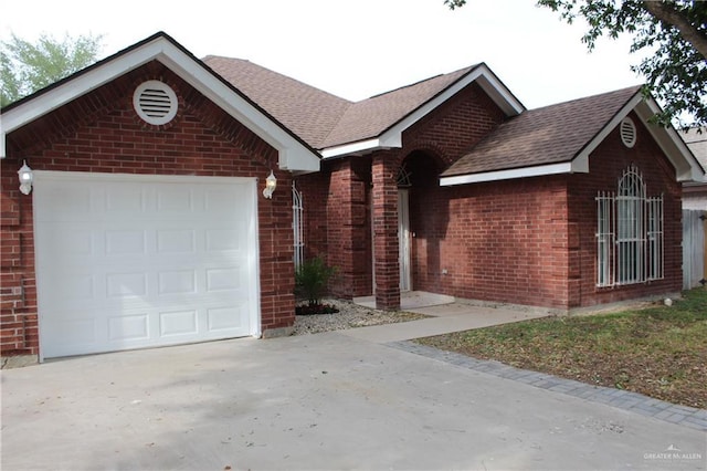 single story home featuring concrete driveway, an attached garage, and brick siding