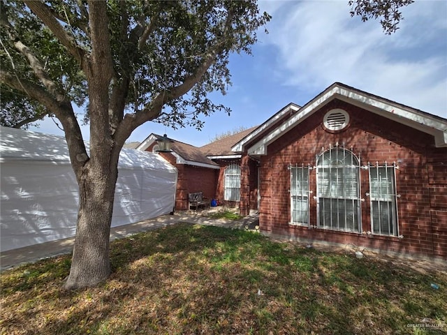 view of front of property with brick siding and a front lawn