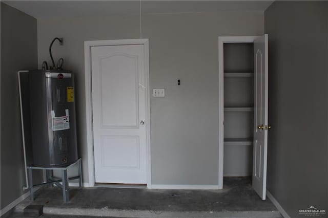 interior space with baseboards and water heater