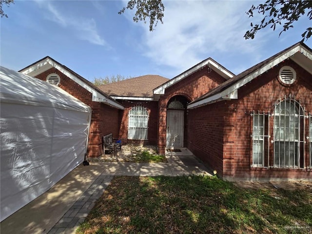 ranch-style house with a patio and brick siding